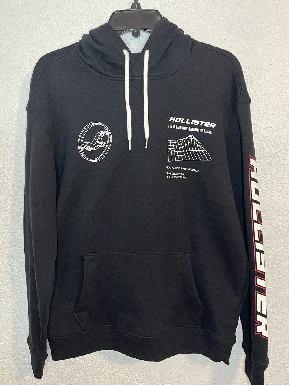 Hollister Black Pullover Hoodie with White Graphics and Red Sleeve Logo
